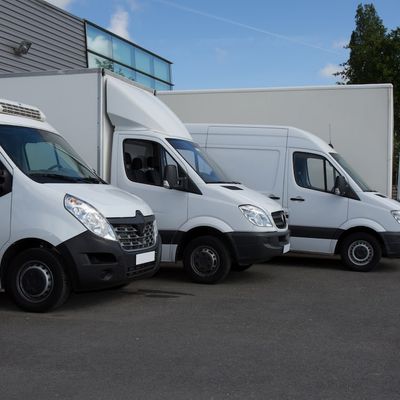 Fleet of white commercial vans parked outside Irish business premises — ideal for delivery companies seeking van finance, leasing, or fleet funding in Ireland