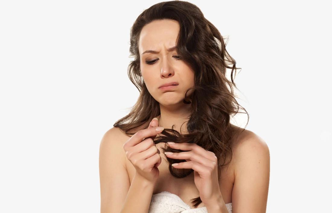 A woman holding her hair in despair as they are dry and hard