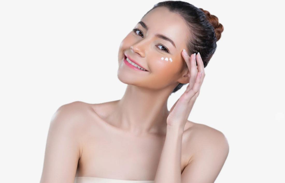 a woman applying cream below eyes