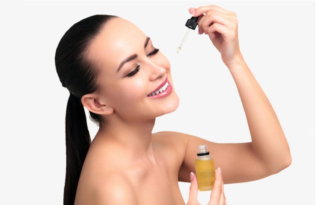 A woman putting a drop of olive oil on her skin