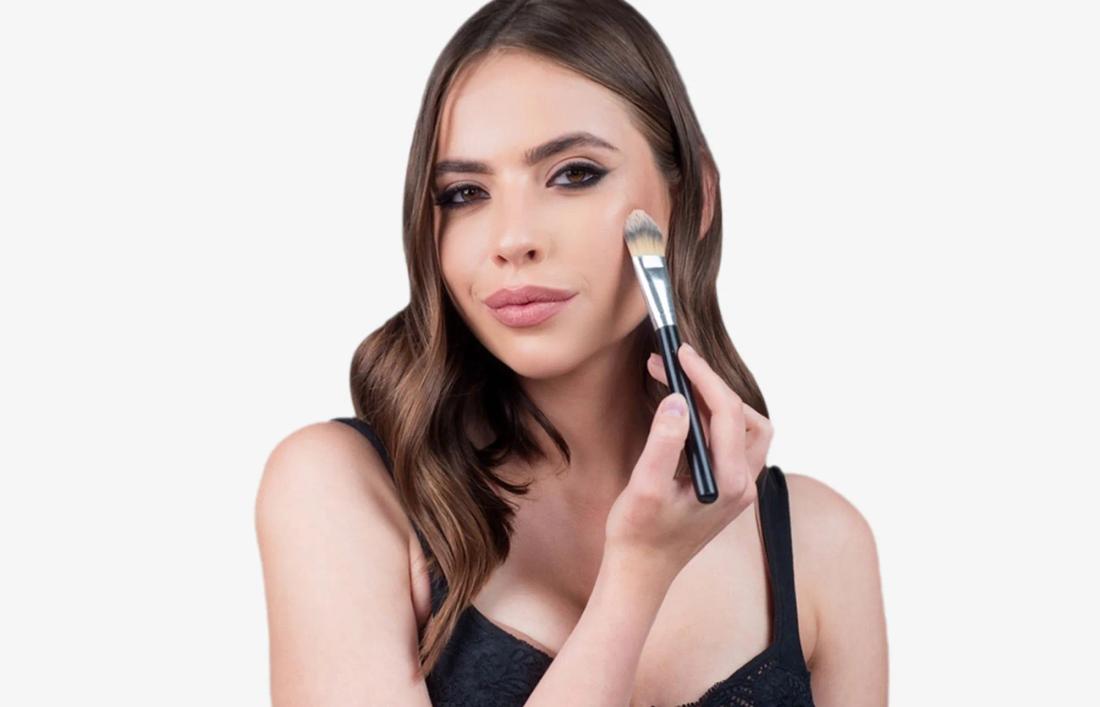A woman applying some blush on her face