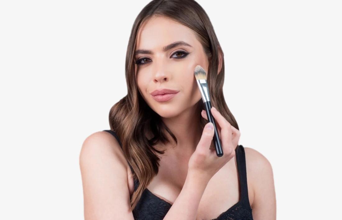 A woman applying some blush on her face