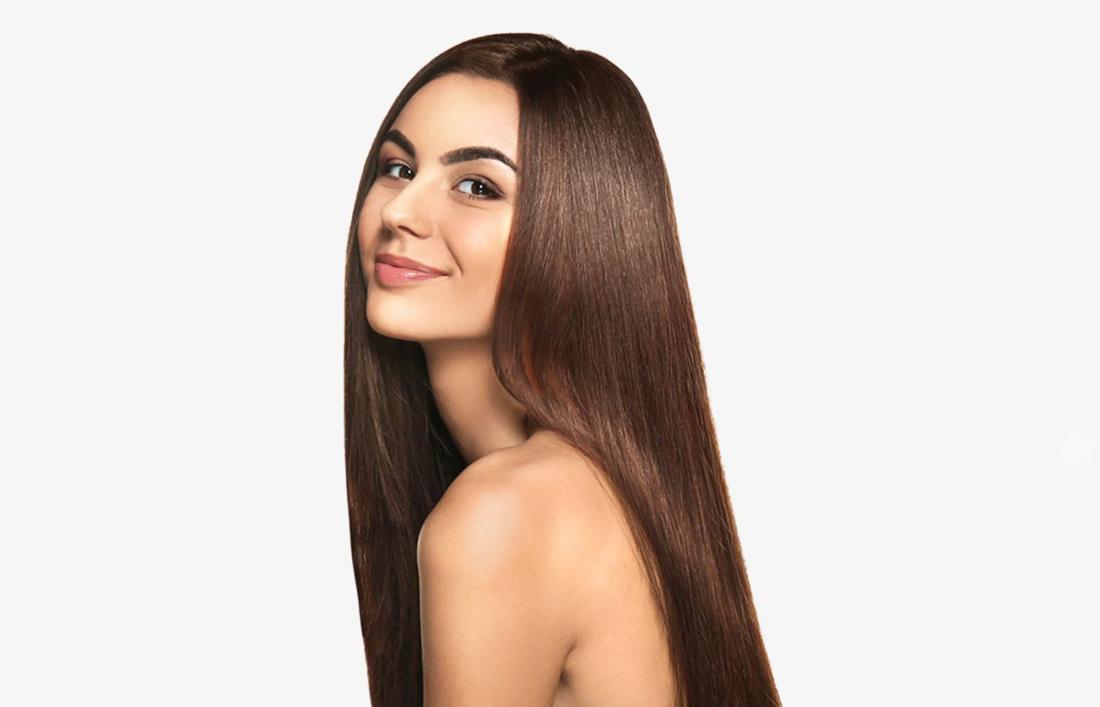 A sidewards pose of a woman smiling and showing her straight hairs