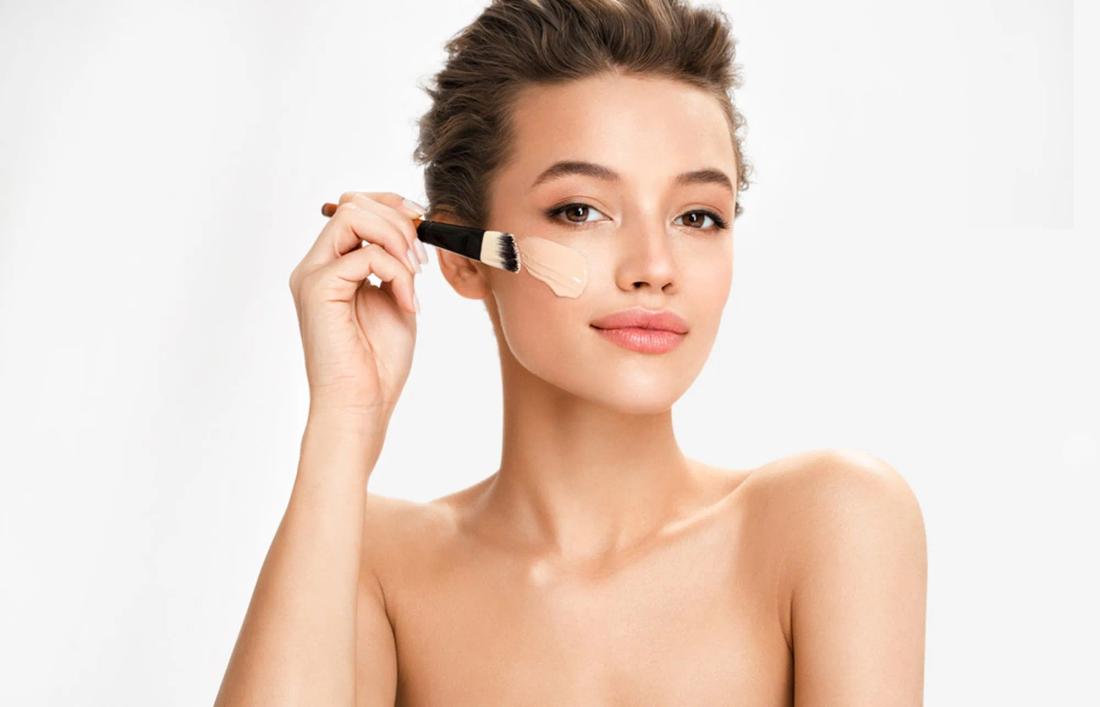 A woman applying foundation on her face for diwali ready look
