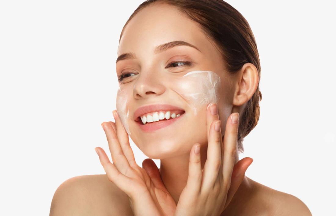 A woman with smiling face with cream applied on face