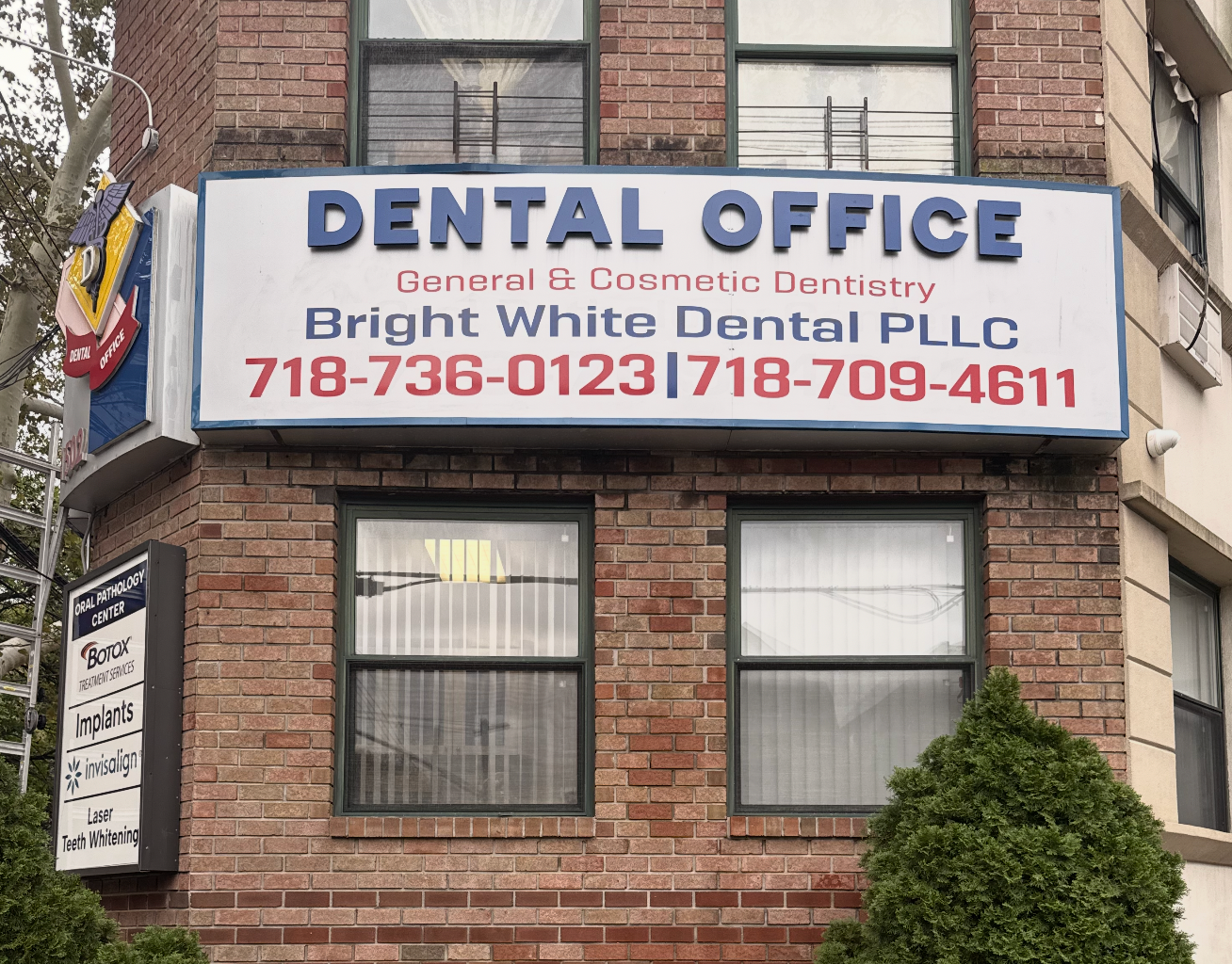 The Bright White Dental sign on the brick front of our Midwood office