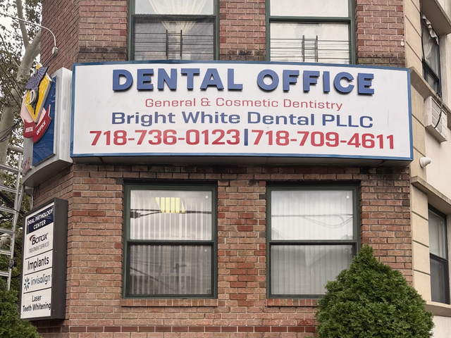 The Bright White Dental sign on the brick front of our Midwood office