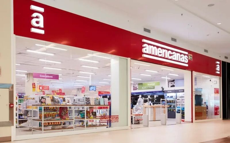 Fachada da loja Americanas com vitrine iluminada e logo visível