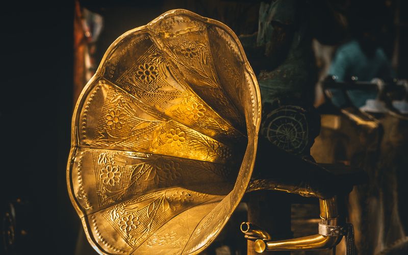 Artista no palco do Grammy com troféu brilhante e luz de destaque