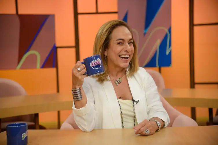 Estúdio de TV moderno com apresentadora em bancada de transmissão