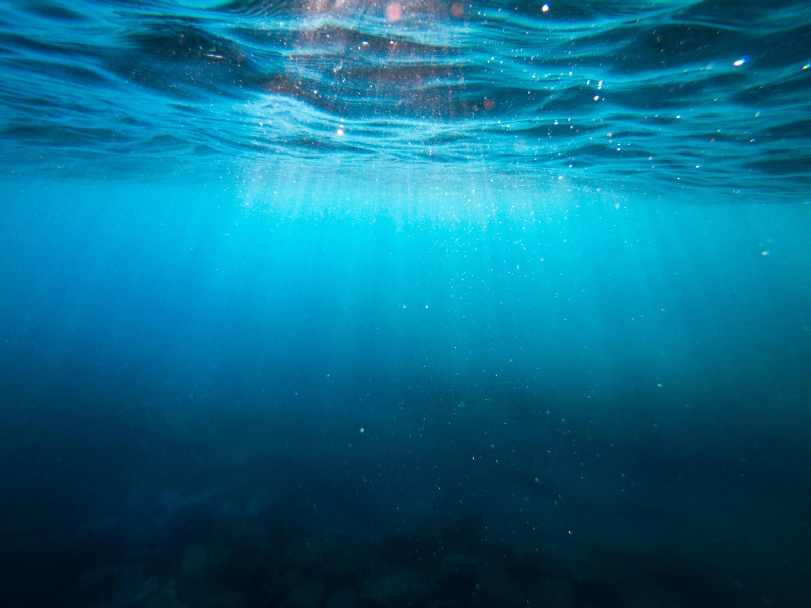 Oceano azul com ondas sob céu nublado em cenário de preservação