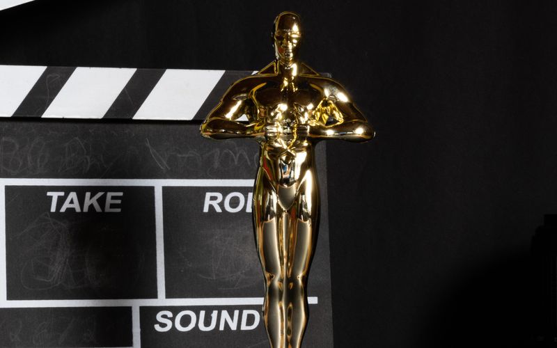 Estatueta do Oscar em destaque sob iluminação de palco dourada