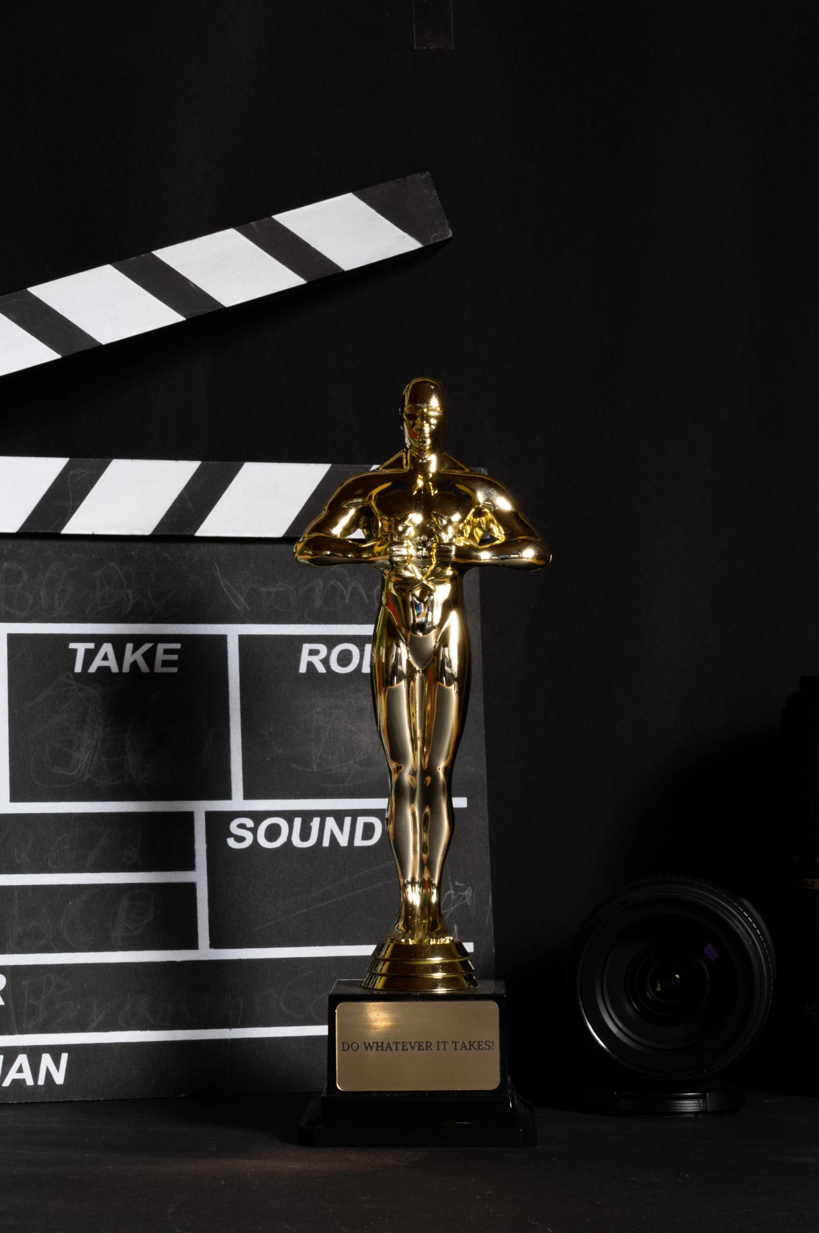 Estatueta do Oscar em destaque sob iluminação de palco dourada