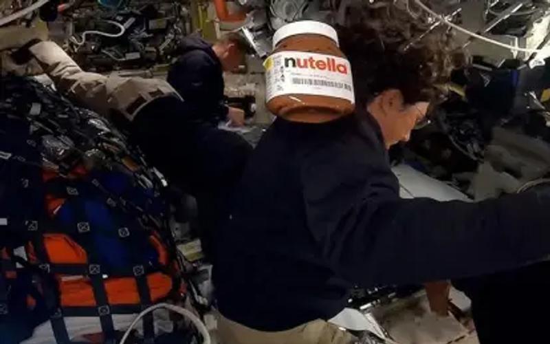 Pote de Nutella flutuando em gravidade zero dentro de nave espacial.
