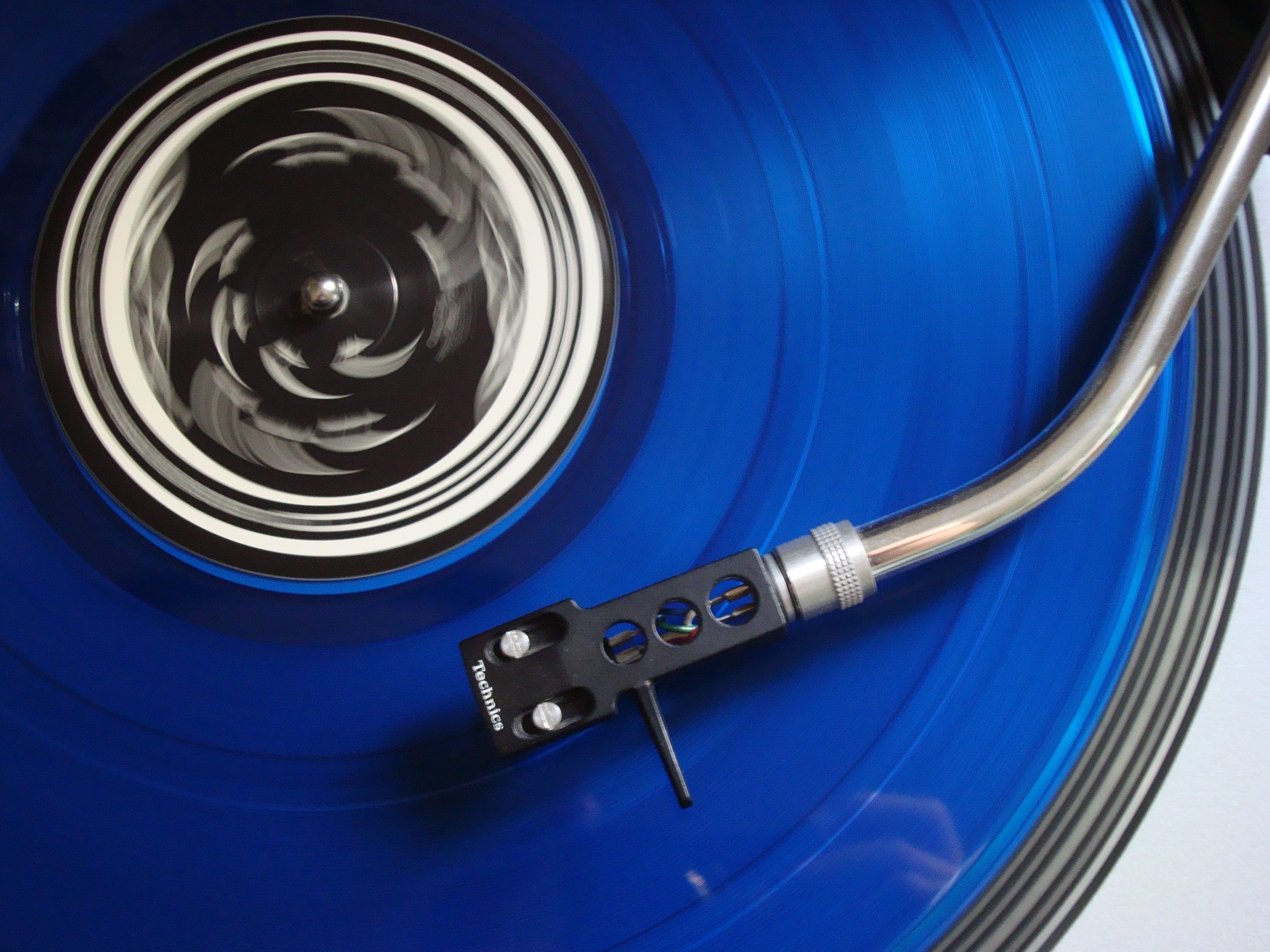 Disco de vinil ao lado de smartphone mostrando aplicativo de música