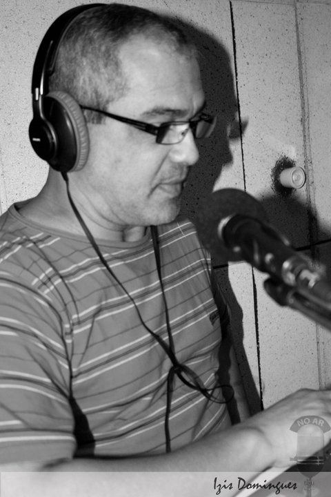 Anselmo Verissimo em estúdio de rádio com fones e microfone