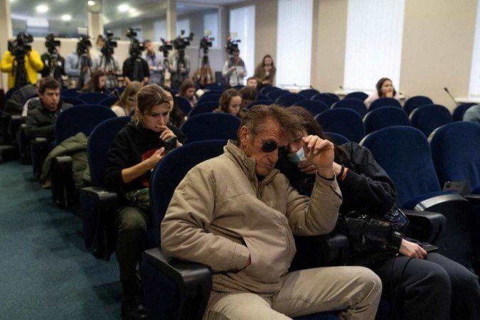 Ator Sean Penn em localização urbana durante conflito armado internacional