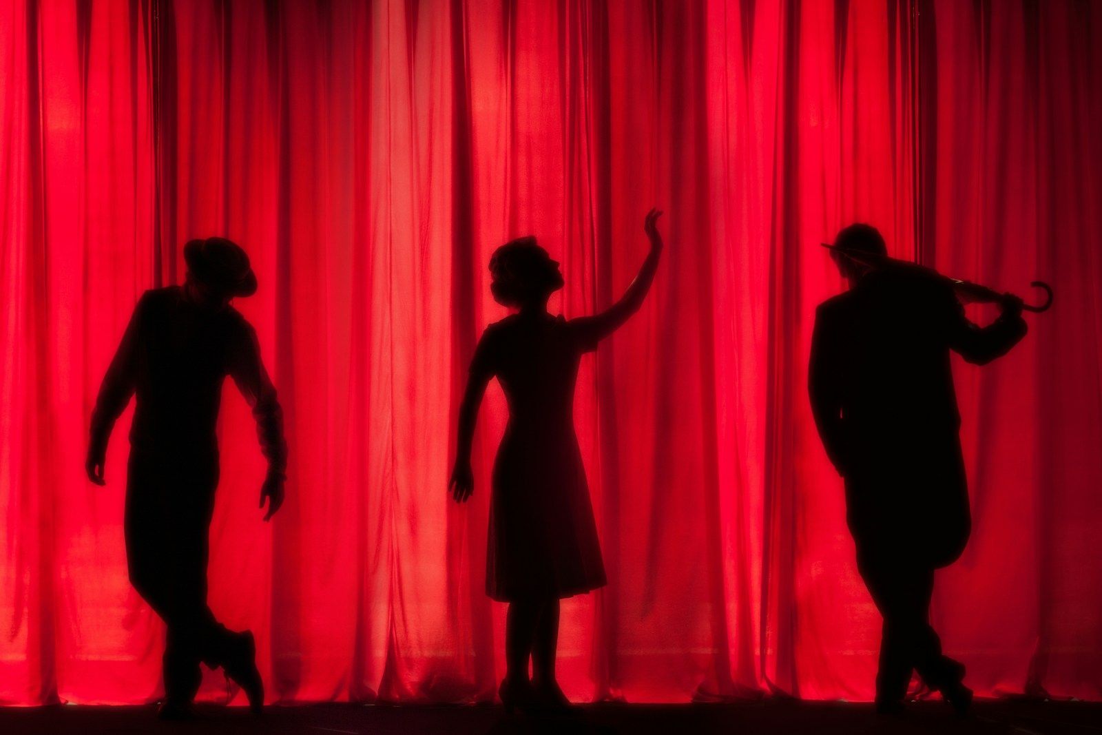 Palco iluminado num teatro vazio antes do espetáculo começar, representando a estrutura concreta por trás da carreira de quem vive de arte no Brasil.