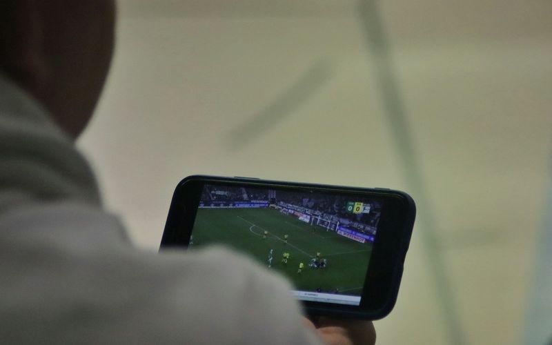 Pessoa assistindo a um jogo de futebol ao vivo na tela do celular