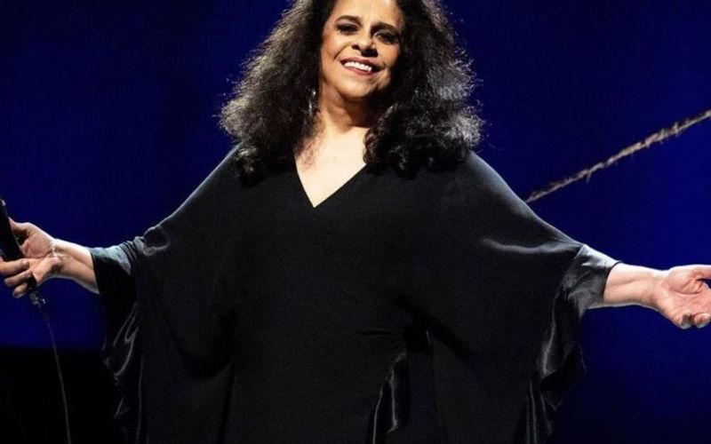 Gal Costa em apresentação musical em palco com iluminação colorida