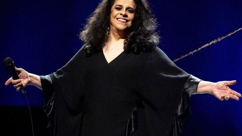 Gal Costa em apresentação musical em palco com iluminação colorida