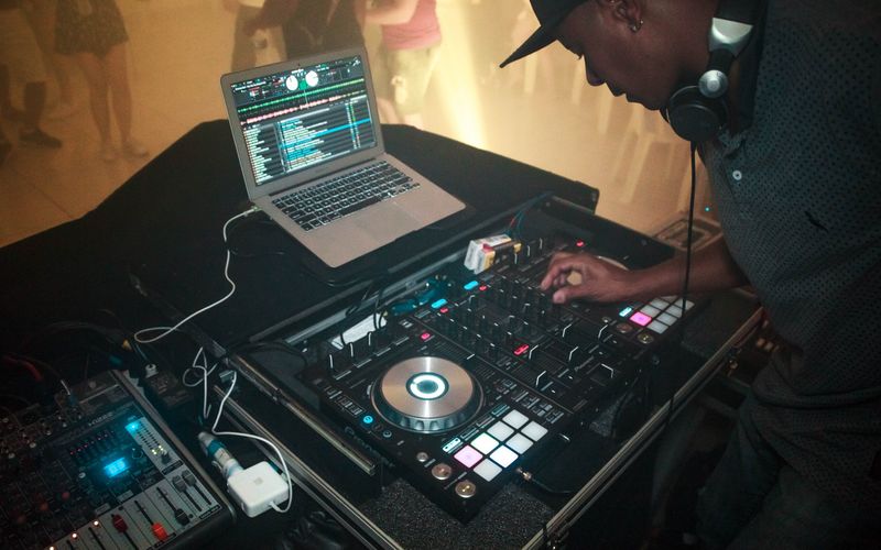 DJ em cabine com equipamento de áudio em evento musical