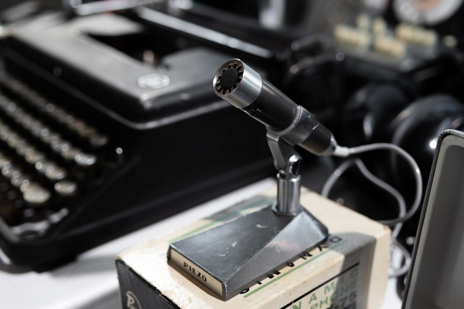 Microfone vintage de transmissão ao lado de uma máquina de escrever antiga, evocando a era das primeiras radiotransmissões esportivas dos anos 1930