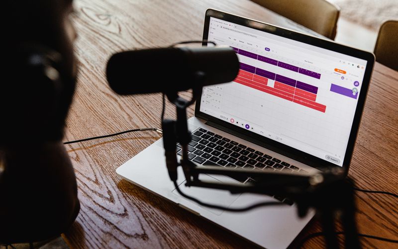 Criador de conteúdo analisando gráficos de audiência de podcast