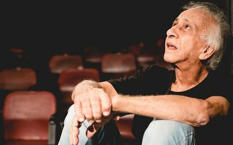 Palco de teatro com cortinas vermelhas e iluminação cênica