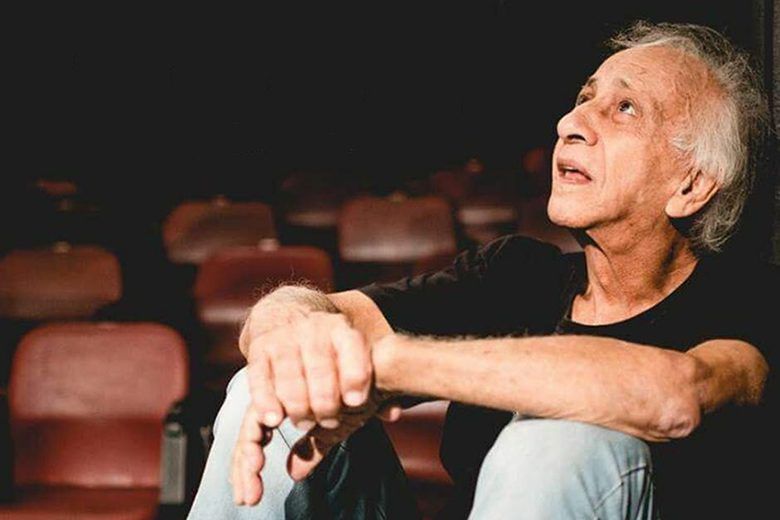 Palco de teatro com cortinas vermelhas e iluminação cênica