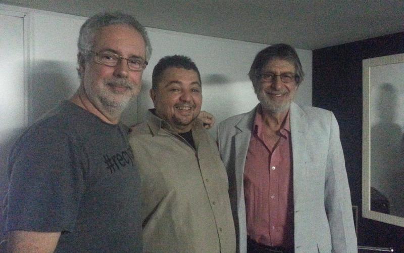 Professor em estúdio de dublagem orientando aluno em microfone