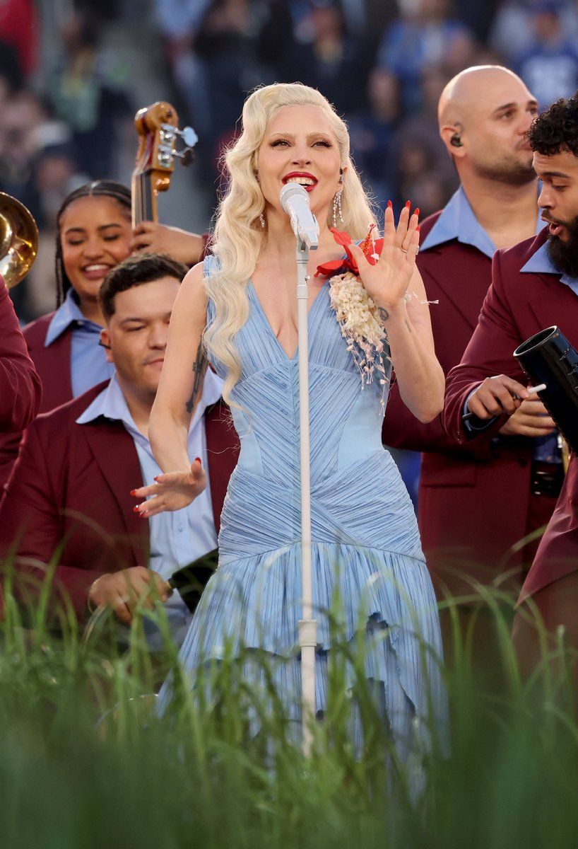 Lady Gaga no palco em figurino azul com flores durante Super Bowl