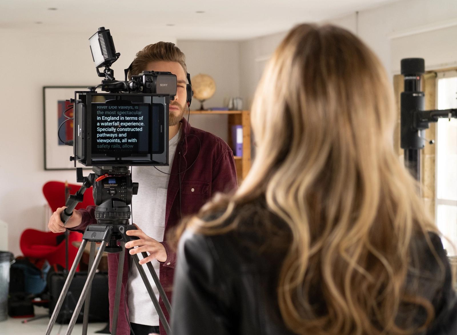 Apresentador usando teleprompter digital em estúdio de televisão