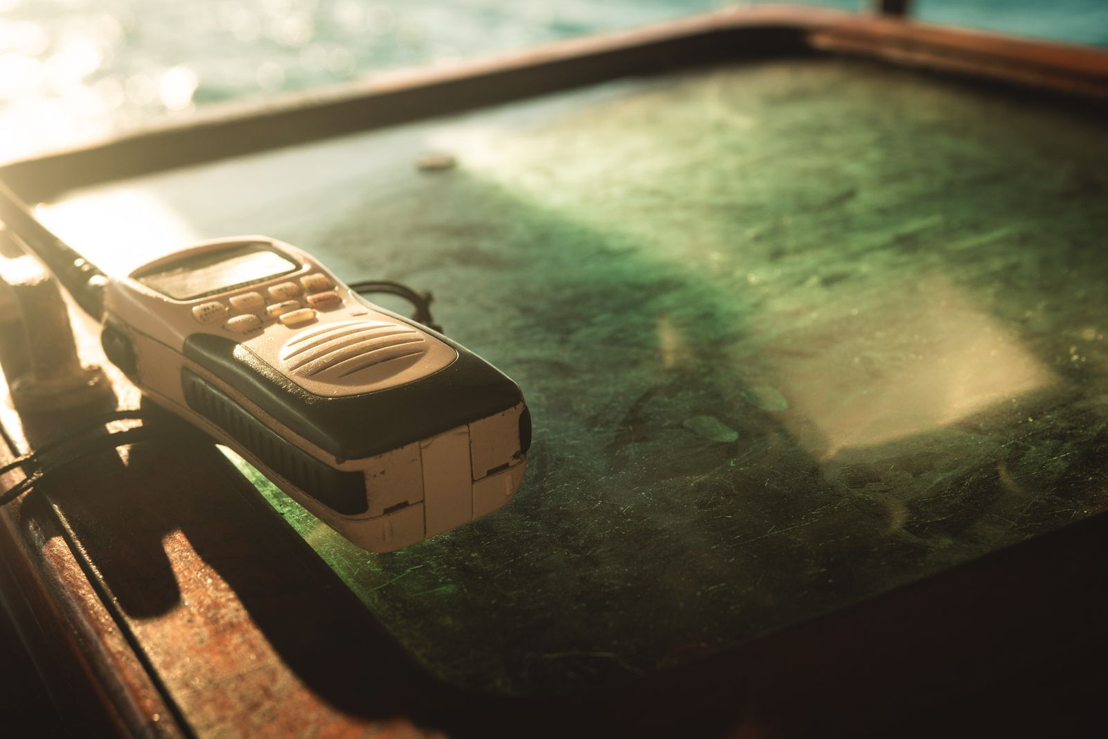 Walkie-talkie antigo pousado sobre uma superfície iluminada pela luz dourada do entardecer, remetendo à nostalgia das comunicações via rádio