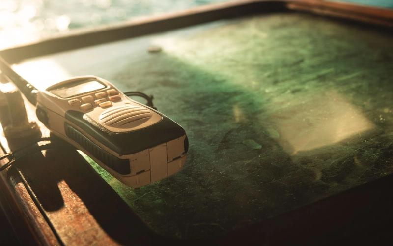 Walkie-talkie antigo pousado sobre uma superfície iluminada pela luz dourada do entardecer, remetendo à nostalgia das comunicações via rádio