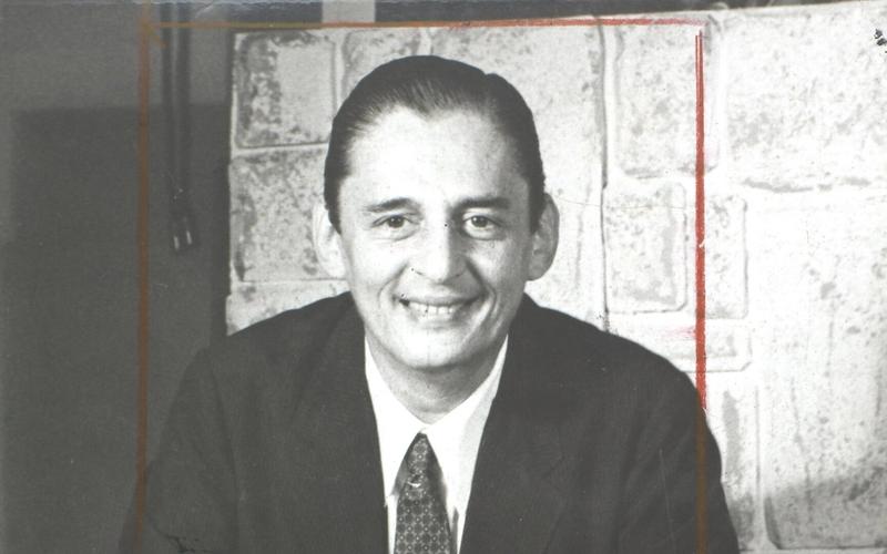 Retrato em preto e branco de César de Alencar sorrindo, de terno e gravata, em setembro de 1972