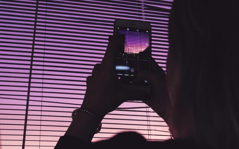 Smartphone em suporte com microfone USB e iluminação caseira ao fundo