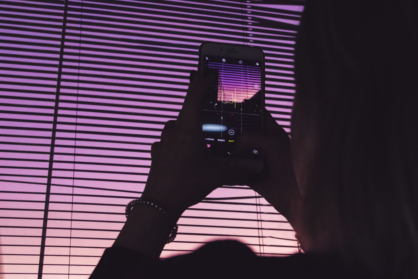 Smartphone em suporte com microfone USB e iluminação caseira ao fundo