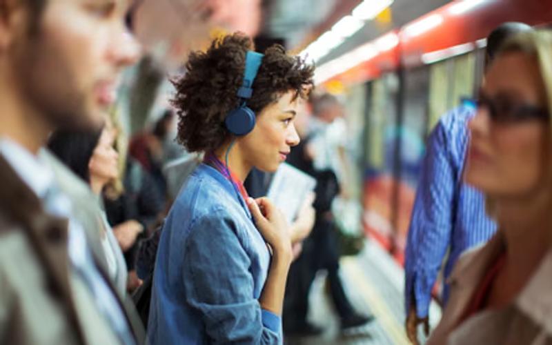 Fones de ouvido branco sobre superfície com ondas sonoras ao redor.