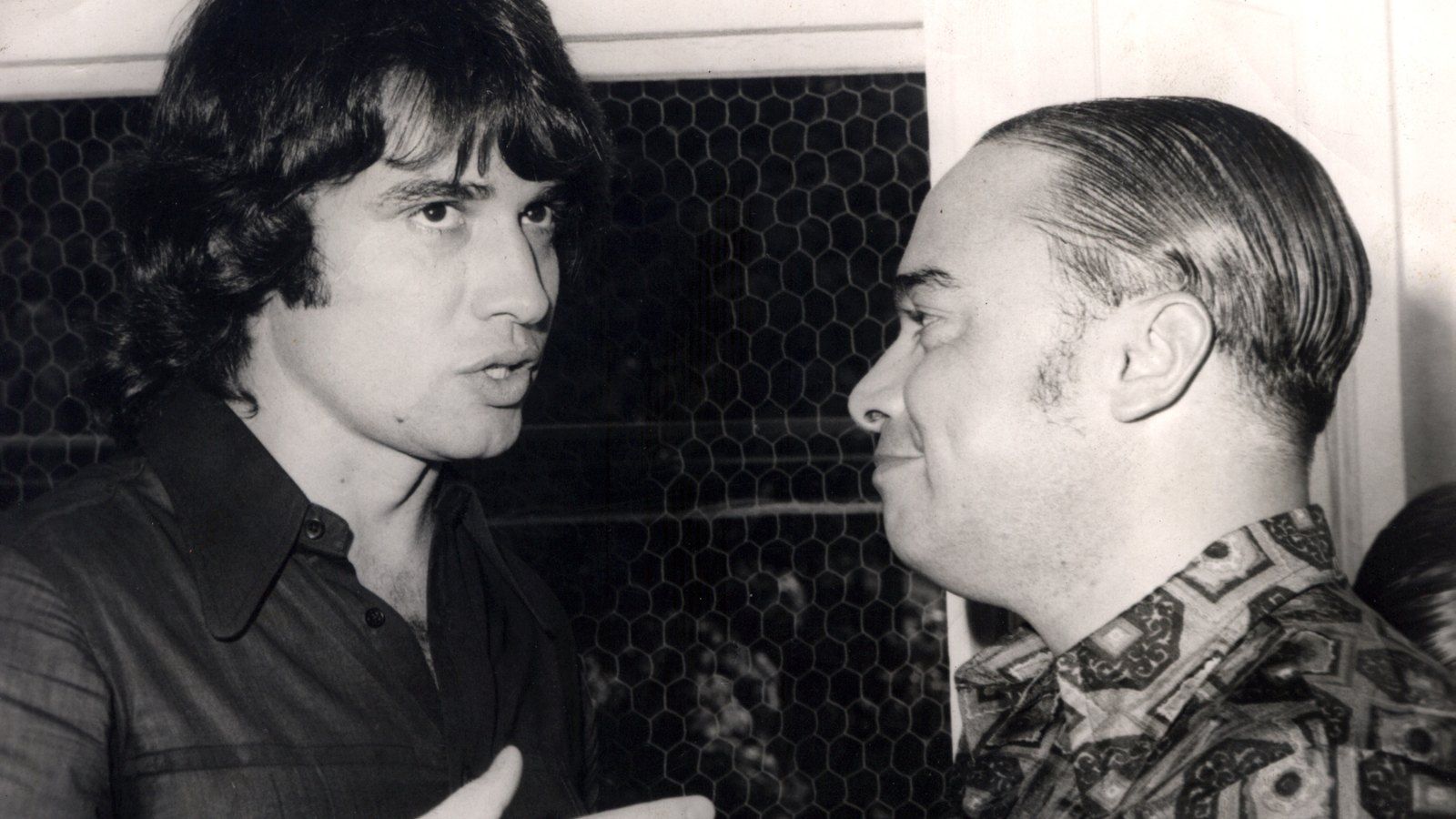 Fotografia em preto e branco de Sérgio Chapelin, jovem, conversando com Haroldo Carvalho Cruz, presidente da Sobeu, na década de 1970