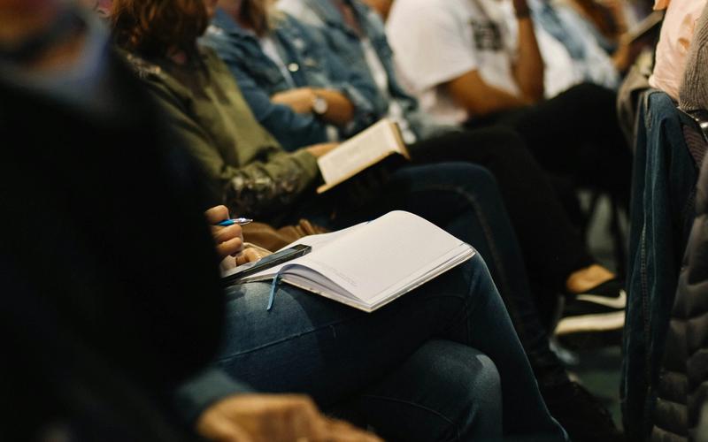 Palco de evento com painéis e público de criadores e comunicadores