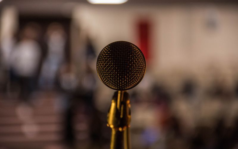 Plateia atenta assistindo apresentação ou debate em ambiente formal