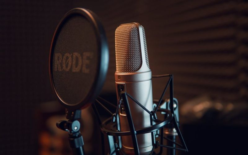 Locutor em estúdio de gravação profissional com microfone