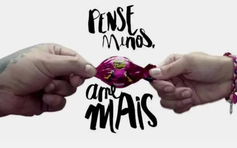 Pessoas olhando para painéis digitais da cidade com mensagens de amor