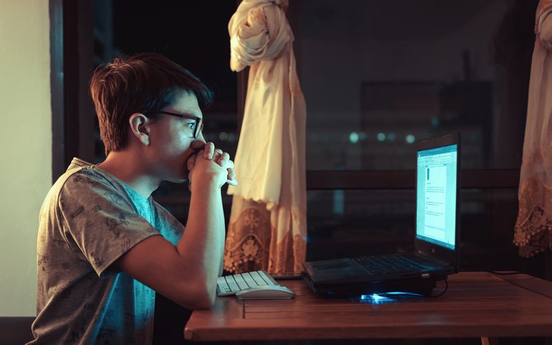 Crianças e adolescentes sentados em computadores em sala de aula