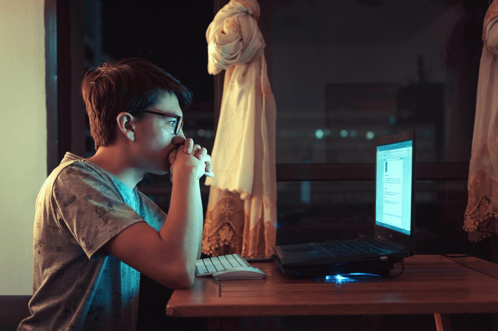 Crianças e adolescentes sentados em computadores em sala de aula
