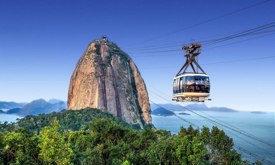 Bondinho vermelho do Pão de Açúcar em trajeto aéreo sobre a baía