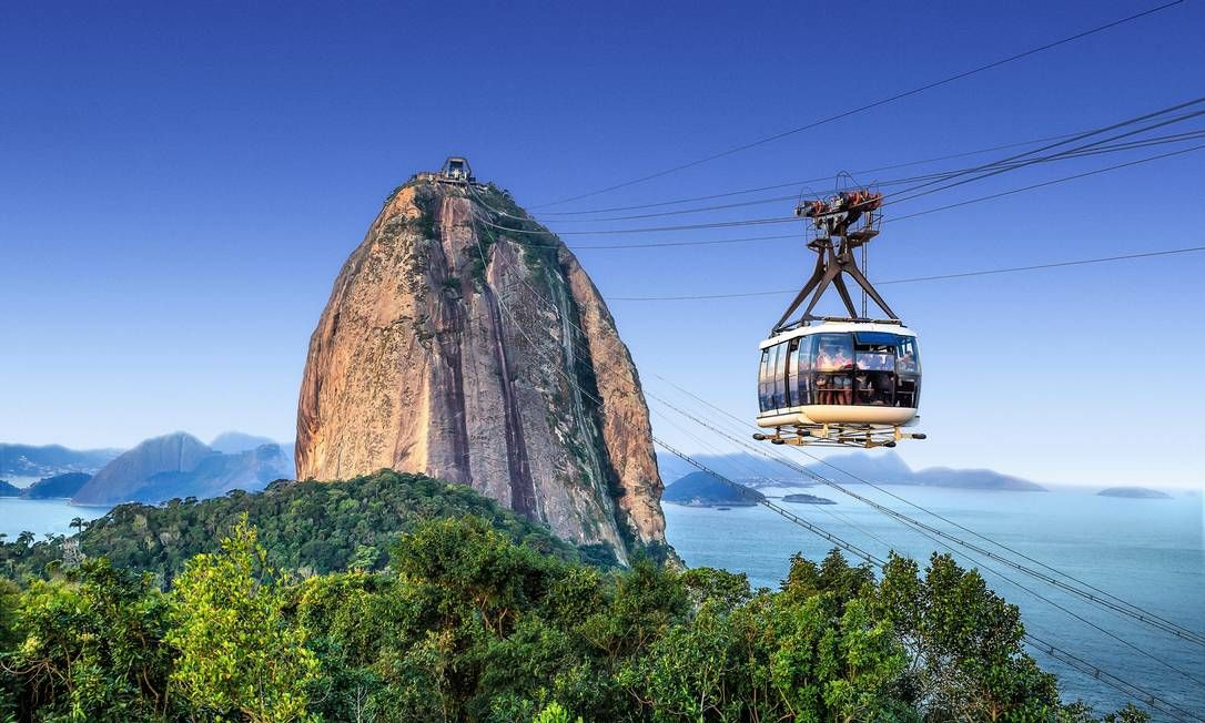 Bondinho vermelho do Pão de Açúcar em trajeto aéreo sobre a baía