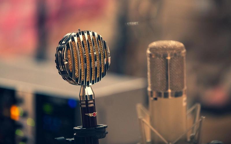 Microfones vintage de estúdio de rádio em close, com luz quente ao fundo, remetendo à era das transmissões esportivas pelo rádio