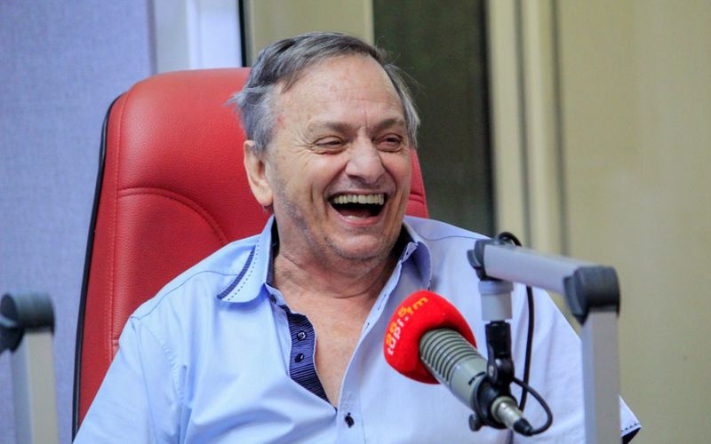 Profissional em estúdio de rádio ao microfone durante transmissão